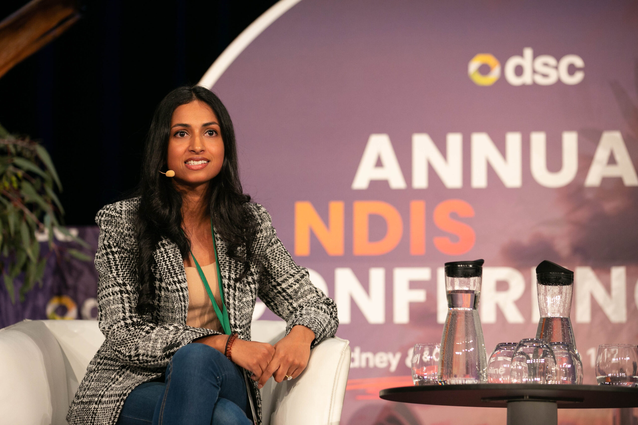 Nikita Fernandes, founder and CEO of Fora Therapy wearing a checkered blazer at a conference.